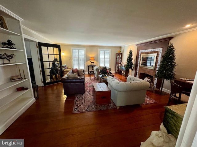 living area with crown molding, a fireplace, baseboards, and wood finished floors