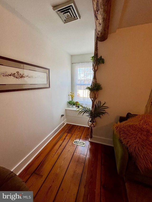 interior space featuring hardwood / wood-style floors, visible vents, and baseboards