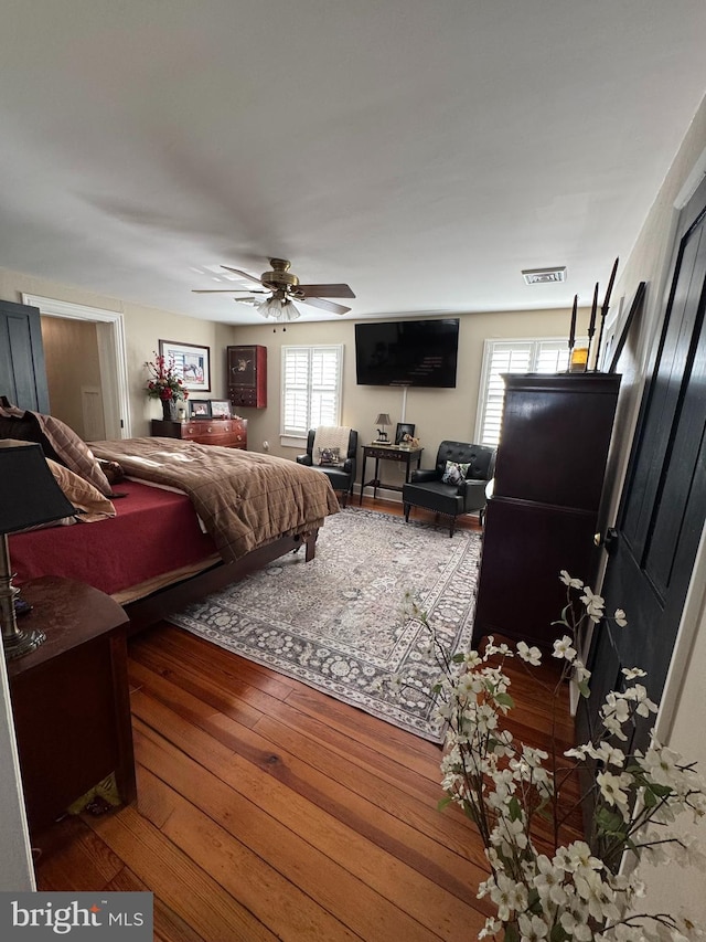 bedroom featuring wood-type flooring, visible vents, and ceiling fan