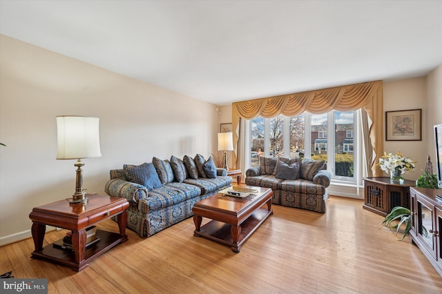 living area with baseboards and light wood-style flooring