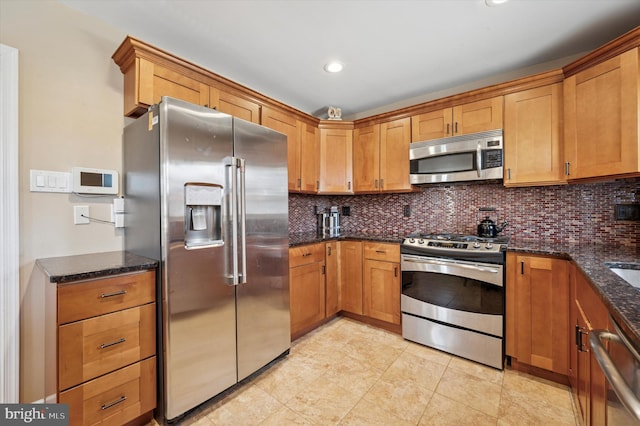 kitchen featuring dark stone countertops, stainless steel appliances, tasteful backsplash, and brown cabinetry