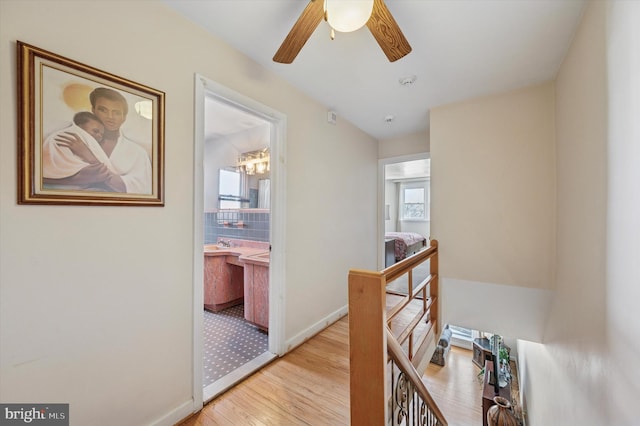 corridor with light wood-style floors and baseboards