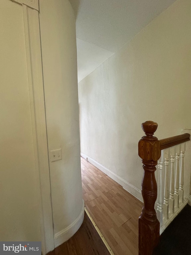 hallway featuring baseboards and wood finished floors