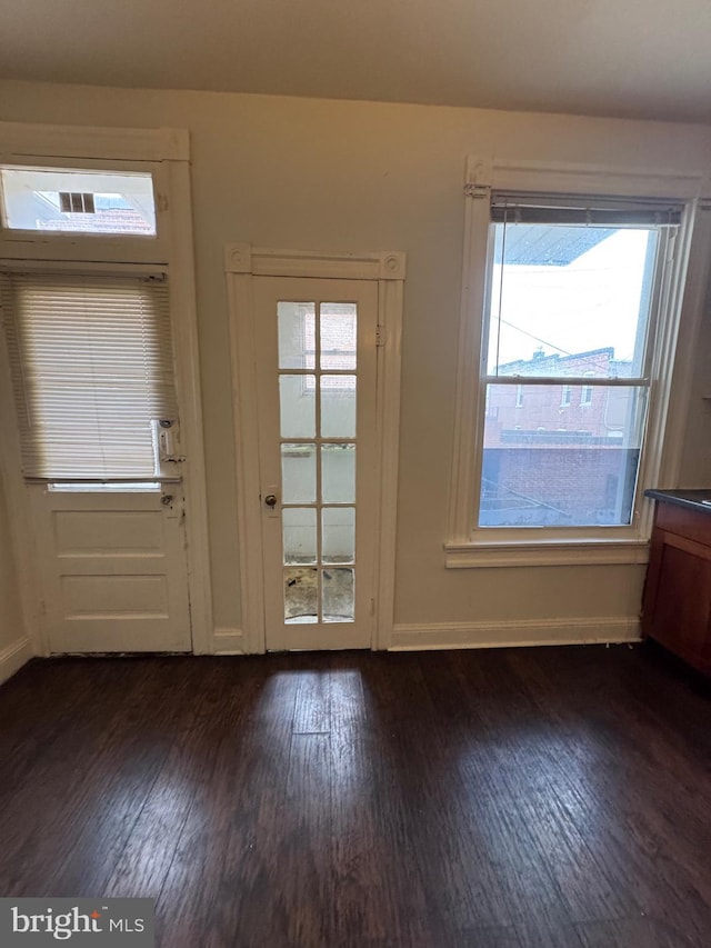 doorway featuring dark wood-style floors and baseboards