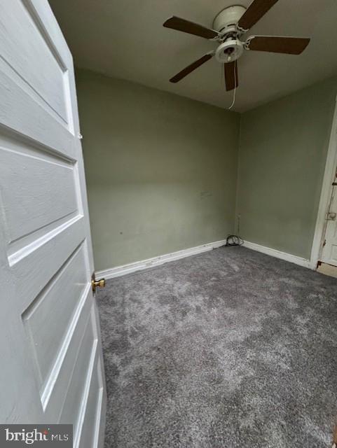 interior space featuring dark carpet and baseboards