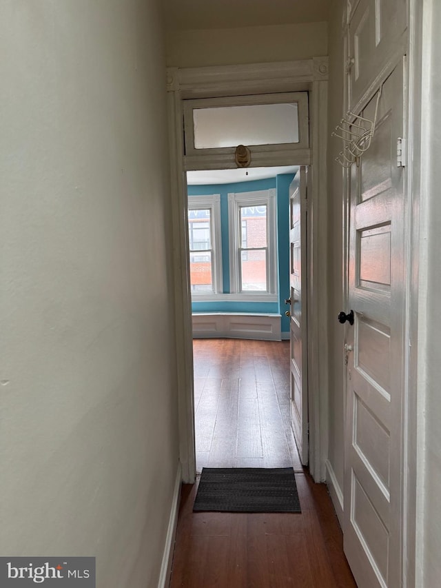 hallway featuring dark wood-style floors and baseboards