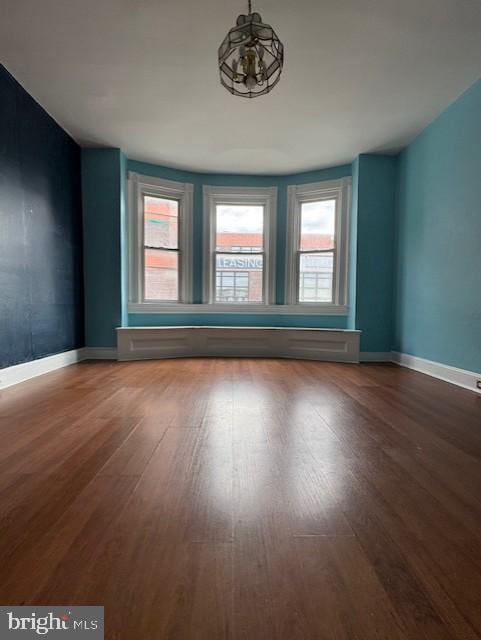 unfurnished room featuring wood finished floors and baseboards