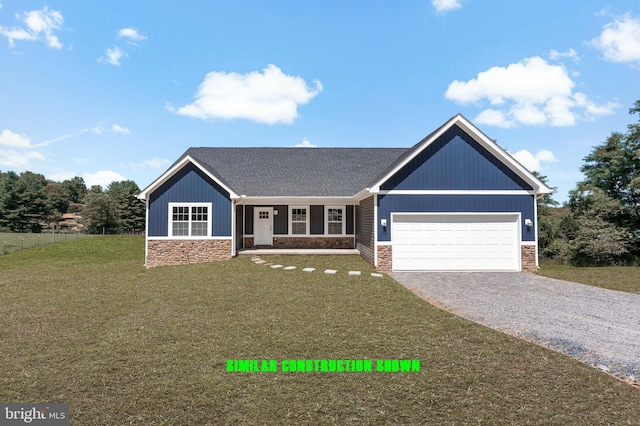 view of front of home with gravel driveway, a front lawn, a garage, and stone siding