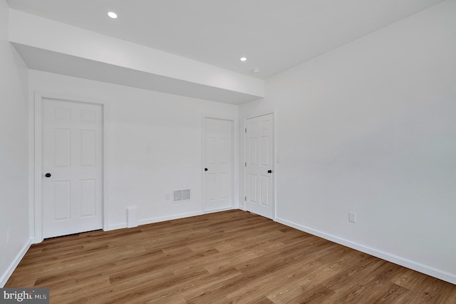 unfurnished room with baseboards, visible vents, and light wood finished floors