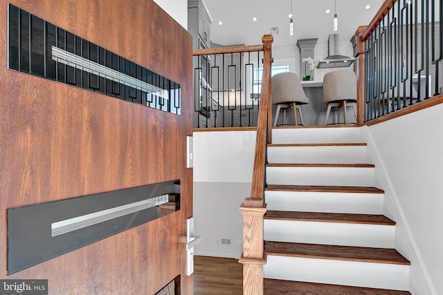 stairs with wood finished floors and visible vents