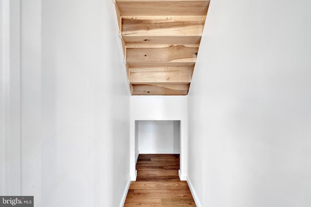 staircase featuring wood finished floors and baseboards