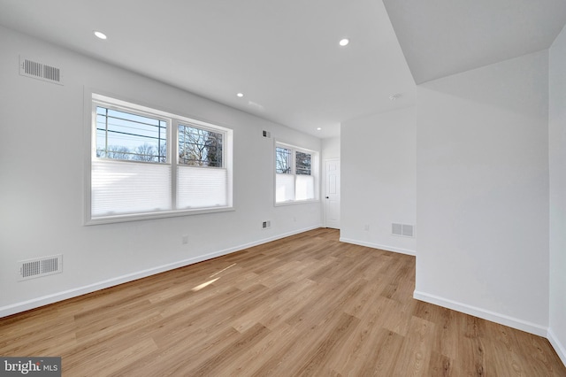 spare room featuring light wood-type flooring, baseboards, visible vents, and recessed lighting