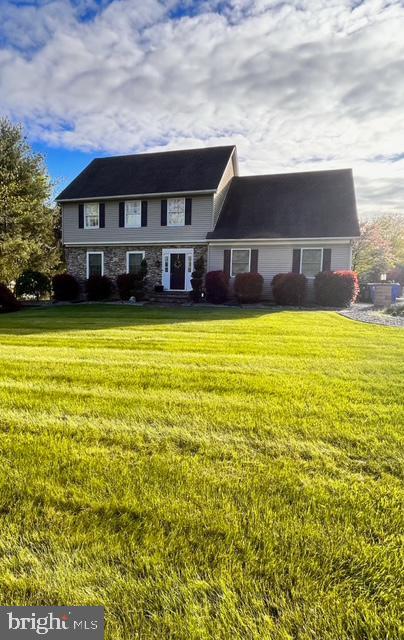 view of front facade with a front yard and stone siding