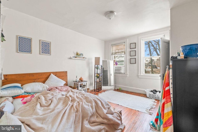 bedroom with wood-type flooring and baseboards