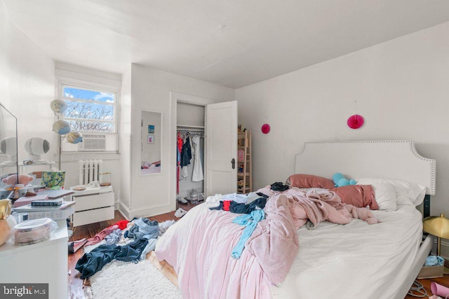 bedroom featuring radiator heating unit, wood finished floors, and baseboards