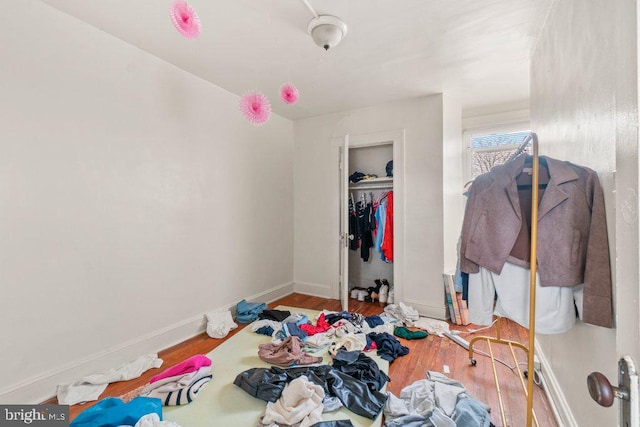 bedroom with a closet, baseboards, and wood finished floors