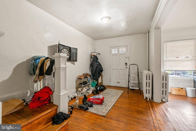 foyer entrance featuring radiator heating unit and wood finished floors