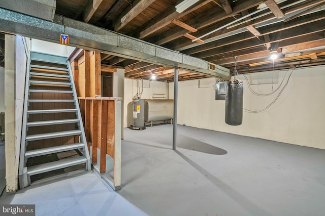 unfinished below grade area with stairs, heating fuel, electric water heater, and electric panel