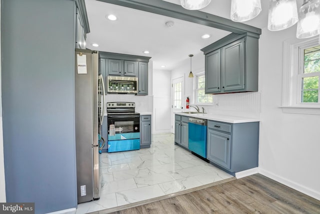 kitchen with appliances with stainless steel finishes, light countertops, recessed lighting, backsplash, and baseboards