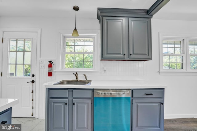 bar area featuring dishwashing machine, plenty of natural light, a sink, and pendant lighting