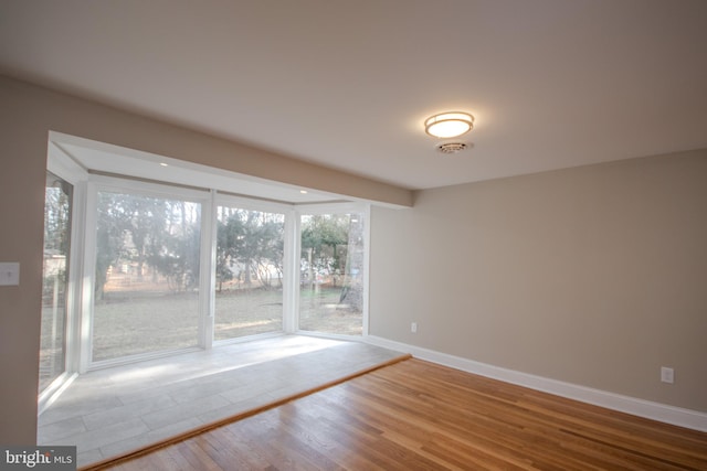 spare room with wood finished floors and baseboards