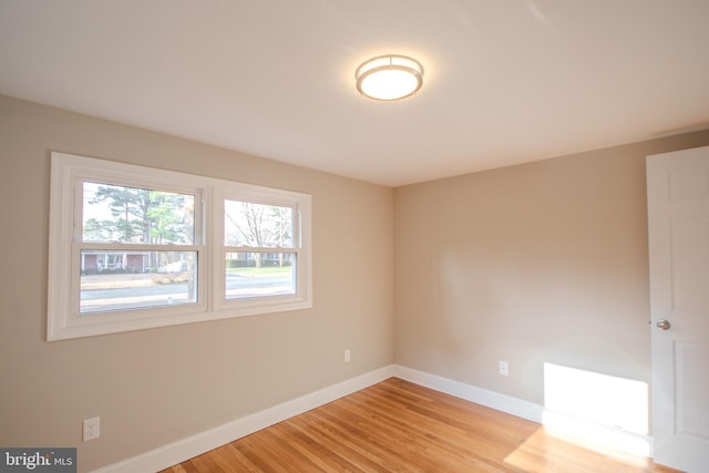 unfurnished room featuring light wood-type flooring and baseboards