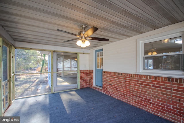 unfurnished sunroom featuring wooden ceiling and ceiling fan