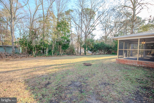 view of yard with a sunroom and ceiling fan