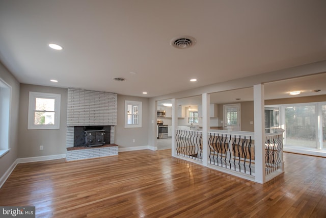 unfurnished living room featuring baseboards, visible vents, wood finished floors, and recessed lighting