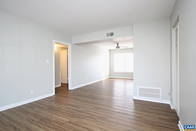 empty room with a ceiling fan, visible vents, baseboards, and wood finished floors