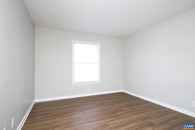 unfurnished room featuring dark wood-type flooring and baseboards