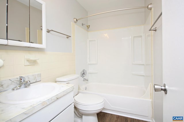 full bathroom with toilet, shower / bathtub combination, wood finished floors, vanity, and tile walls