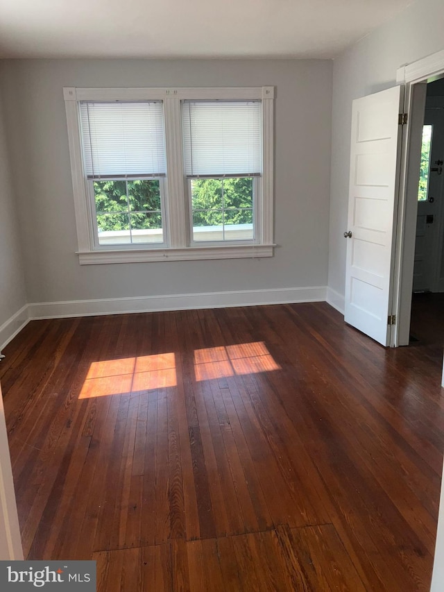 empty room featuring baseboards and hardwood / wood-style flooring