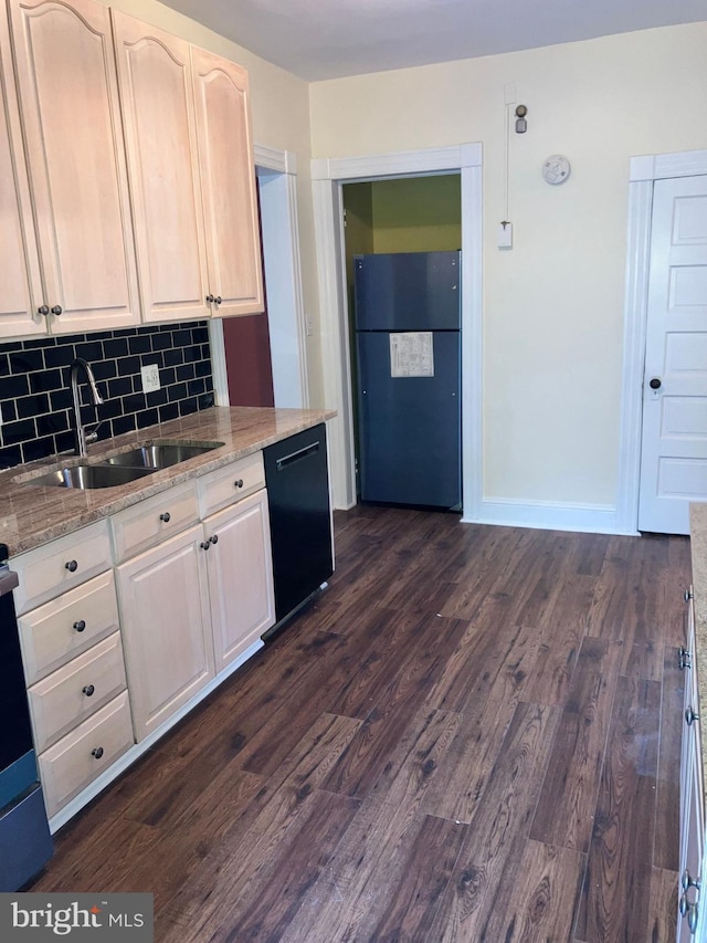 kitchen featuring a sink, freestanding refrigerator, decorative backsplash, dishwasher, and dark wood finished floors