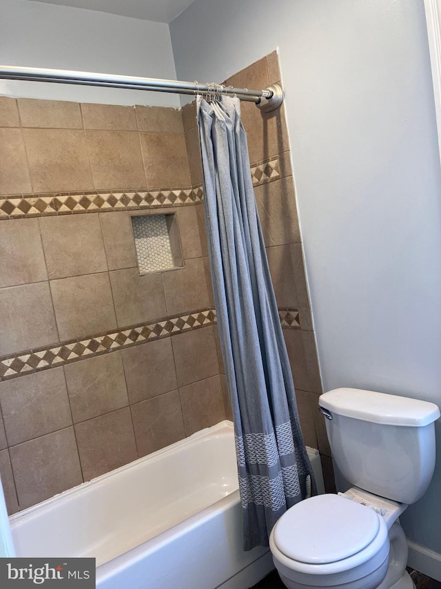 bathroom featuring shower / tub combo with curtain and toilet