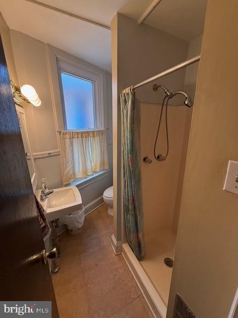 full bathroom featuring tile patterned floors, toilet, and a shower with curtain