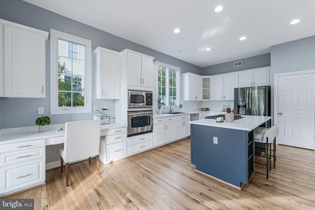 kitchen featuring light countertops, white cabinetry, appliances with stainless steel finishes, and a breakfast bar
