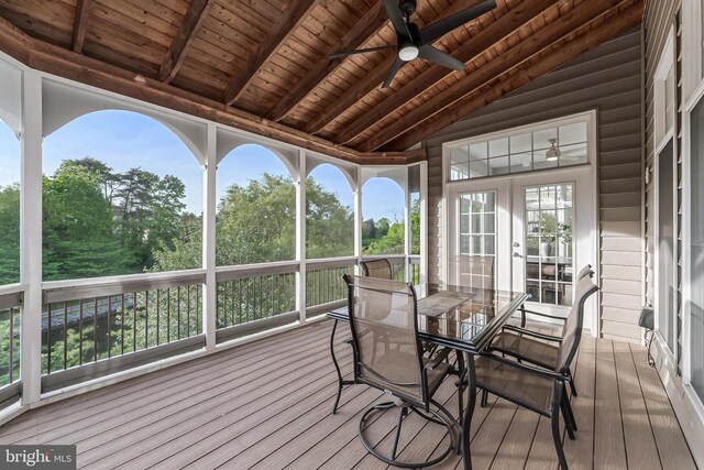 sunroom / solarium featuring french doors, a ceiling fan, and beamed ceiling