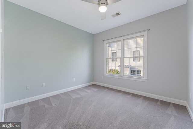 empty room featuring a ceiling fan, baseboards, visible vents, and carpet
