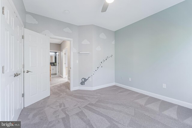 empty room featuring carpet floors, ceiling fan, and baseboards