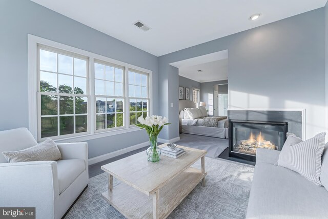 living area with visible vents, recessed lighting, baseboards, and a glass covered fireplace