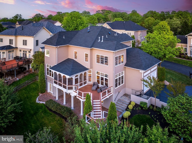 back of property with an attached garage, a shingled roof, stairs, and a wooden deck
