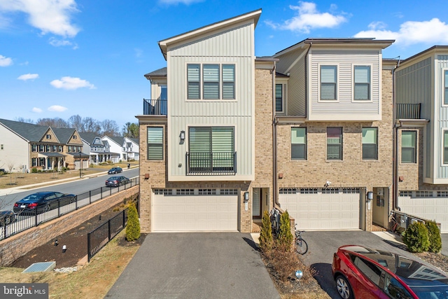 townhome / multi-family property with brick siding, board and batten siding, fence, a residential view, and a garage