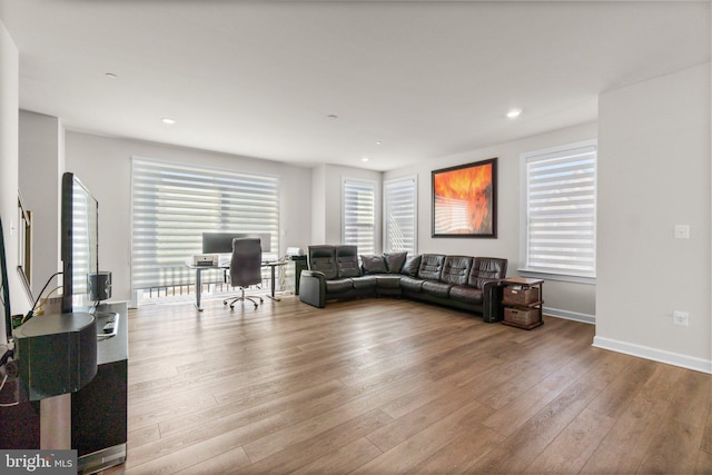 living area with recessed lighting, baseboards, and wood finished floors