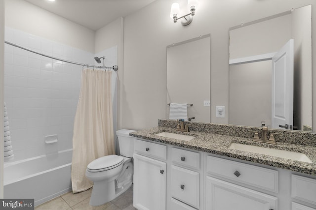 bathroom with tile patterned flooring, double vanity, toilet, and a sink