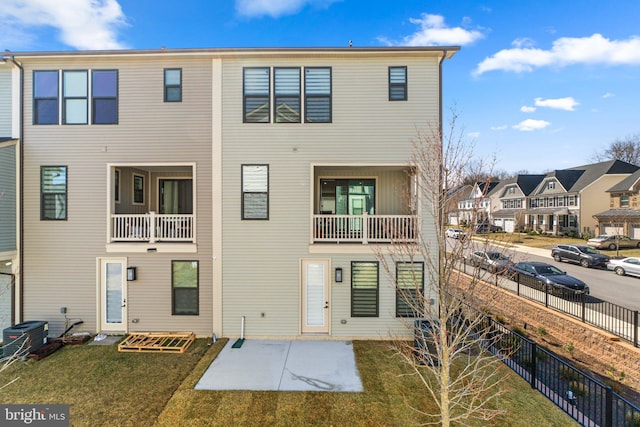 exterior space with cooling unit, a residential view, a patio, and fence