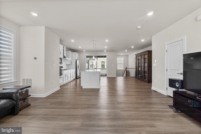 living room featuring recessed lighting, wood finished floors, and visible vents