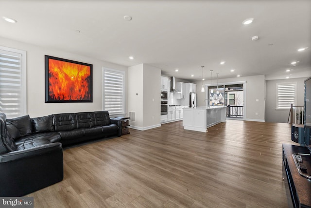 living room featuring recessed lighting, wood finished floors, visible vents, and baseboards