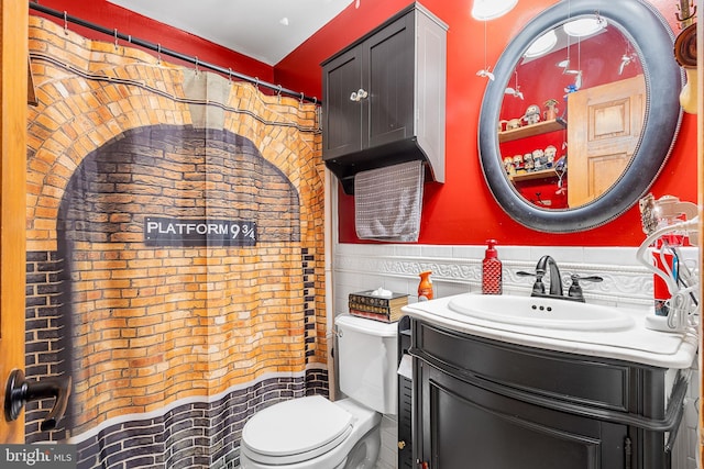 bathroom with wainscoting, vanity, and toilet