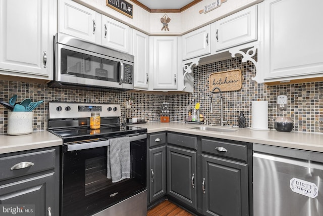 kitchen with stainless steel appliances, a sink, white cabinetry, and gray cabinetry